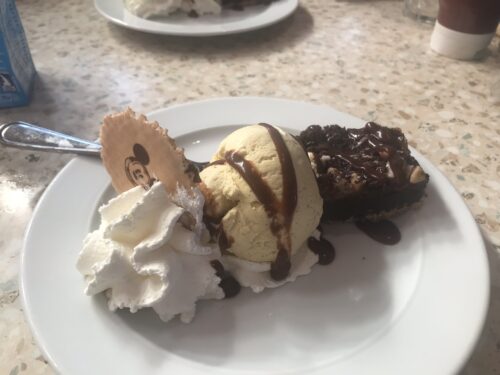A plate of brownie à la mode with whipped cream and chocolate sauce at Annette’s Diner, a delicious treat after a day exploring Disneyland Paris by Eurotunnel.