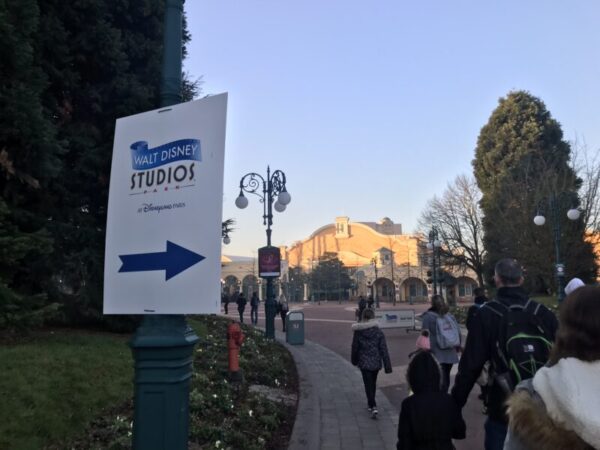 A directional sign for Walt Disney Studios Park at Disneyland Paris, guiding visitors on a sunny morning after arriving by Eurotunnel.