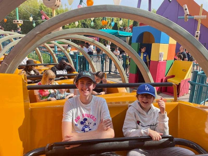 Two boys smiling on Slinky Dog at Walt Disney Studios