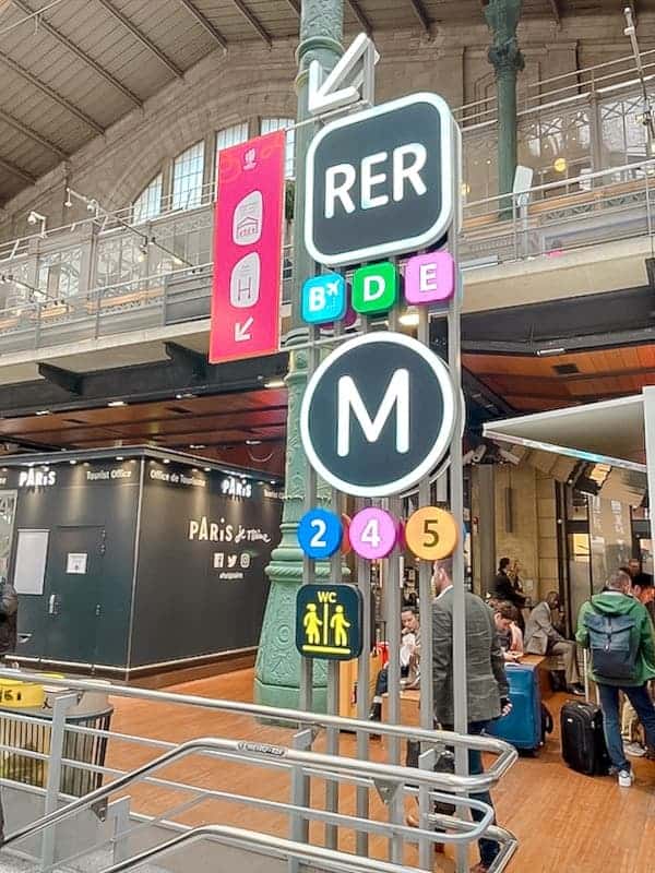The colourful RER Metro sign has a large M on it.