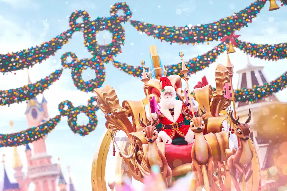 Santa Claus sits atop a brilliant parade float, while Mickey-shaped Christmas garlands decorate Main Street USA