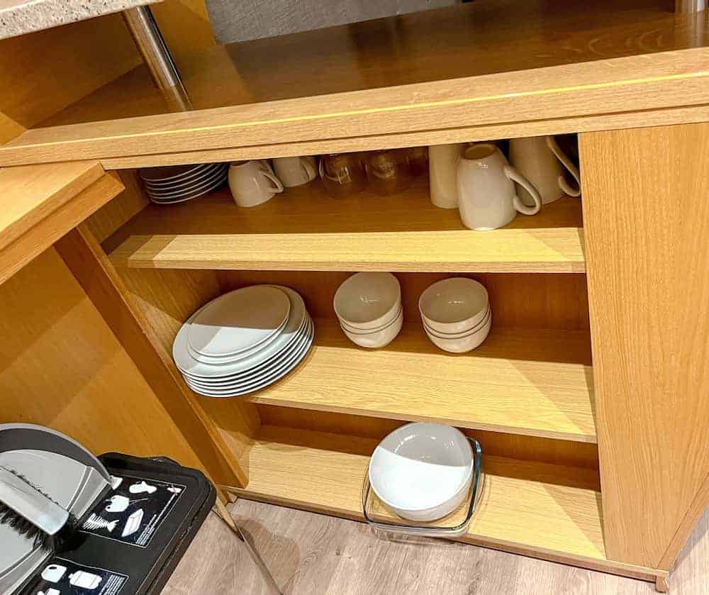 A cupboard filled with plates, bowls and mugs