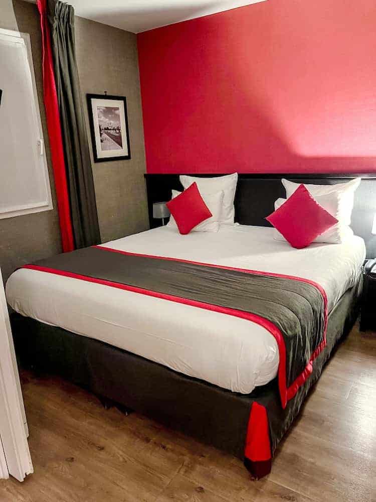 Soft and comfortable bed with red and black throw pillows at Residhome Val d'Europe