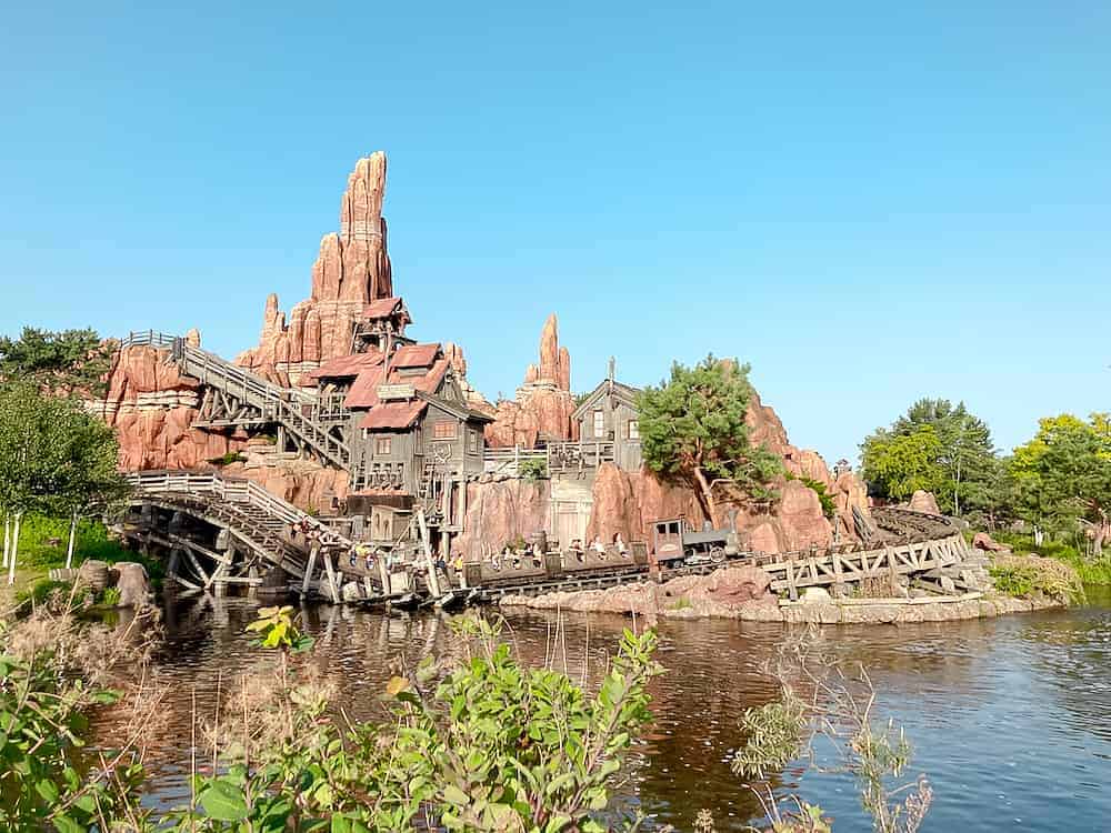 A terracotta-coloured canyon on an island houses Big Thunder Mountain, an iconic rollers coaster in Disneyland Paris