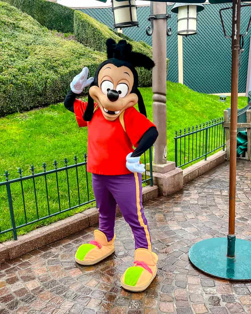 Max Goof posing in bright red and purple outfit during a character meet-and-greet on Main Street U.S.A., one of the surprise Disneyland Paris characters guests can spot during outdoor scheduled appearances.