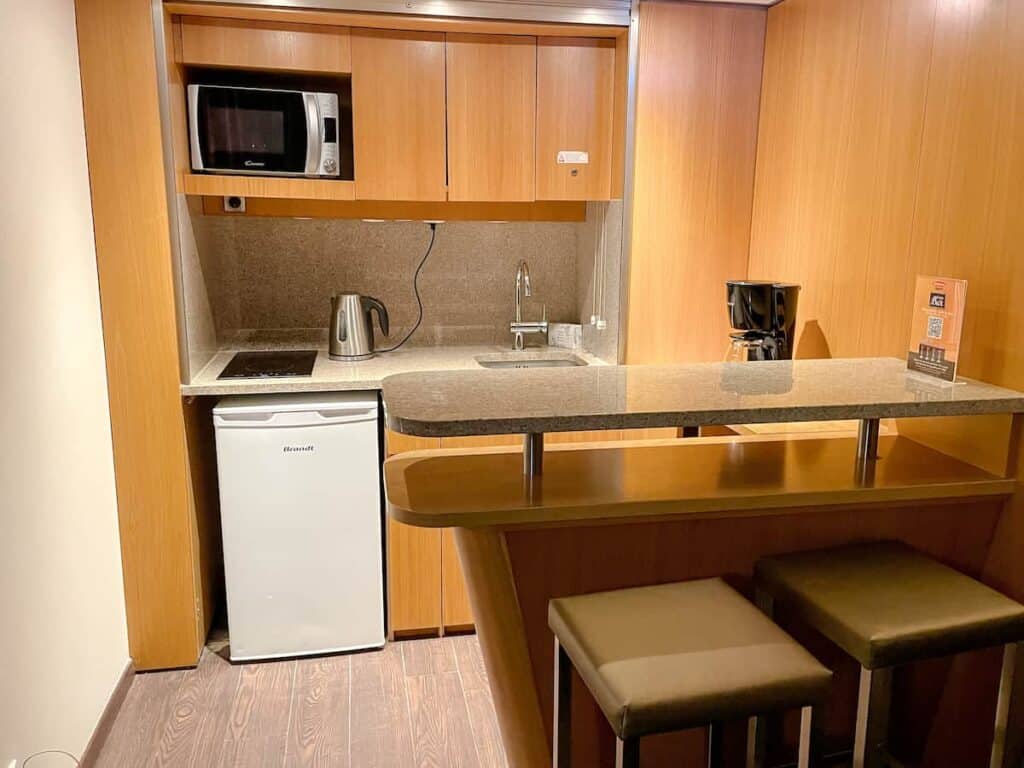 Interior of Residhome Val d'Europe mini suite with refrigerator, microwave, tea kettle, coffee maker and bar for preparing breakfast in the hotel