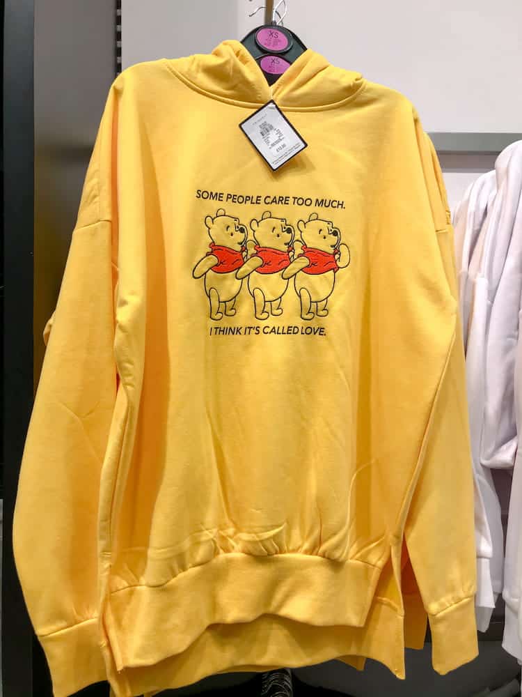 A fun yellow Disney hoodie with Pooh bear stitched on the front