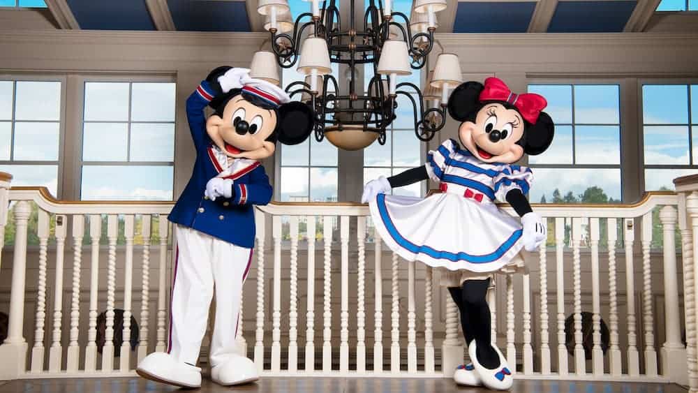 Mickey and Minnie Mouse in sailor outfits greeting guests inside Disney’s Newport Bay Club Hotel at Disneyland Paris.