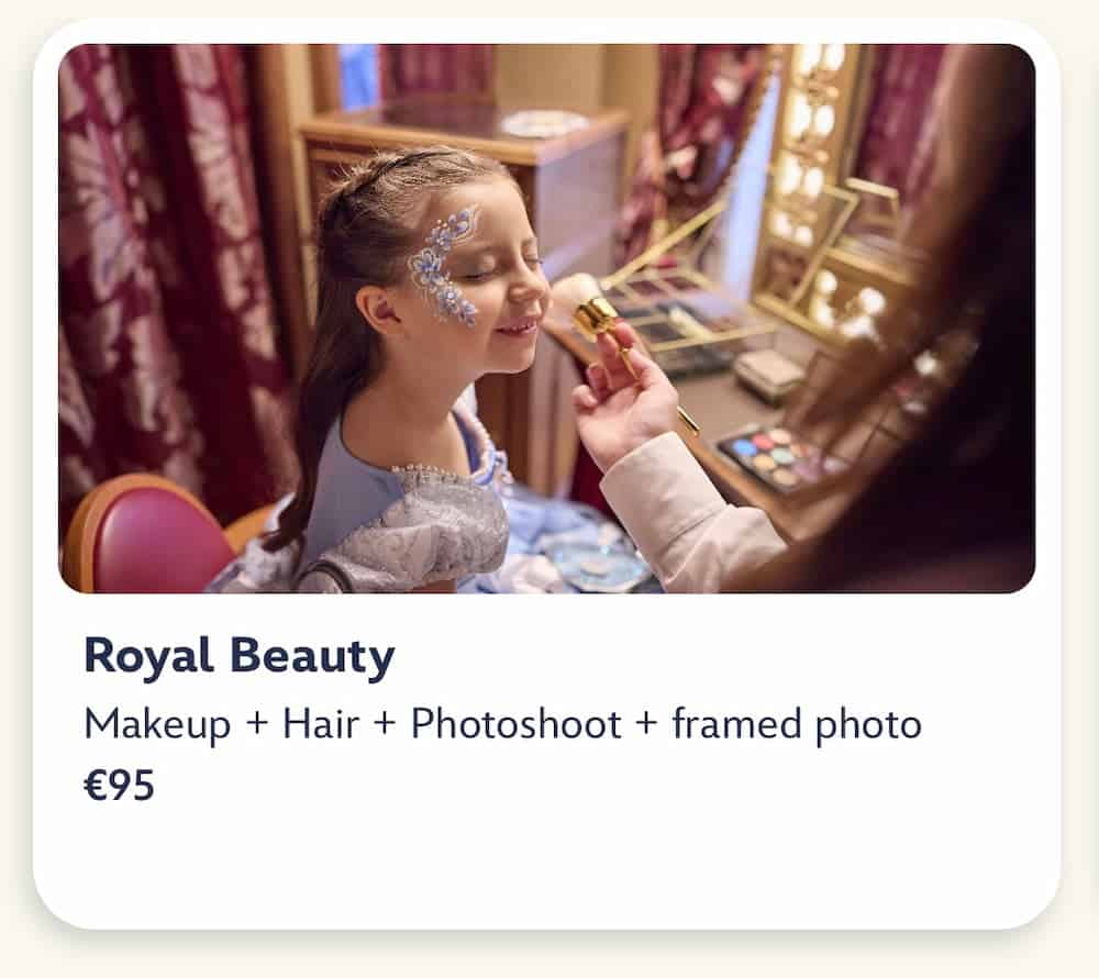 Royal Beauty package details Disneyland Paris: A small girl is having fancy makeup applied by a Disney cast member. A dressing table and mirror is laid out with makeup and brushes. The girl appears to be enjoying the experience.