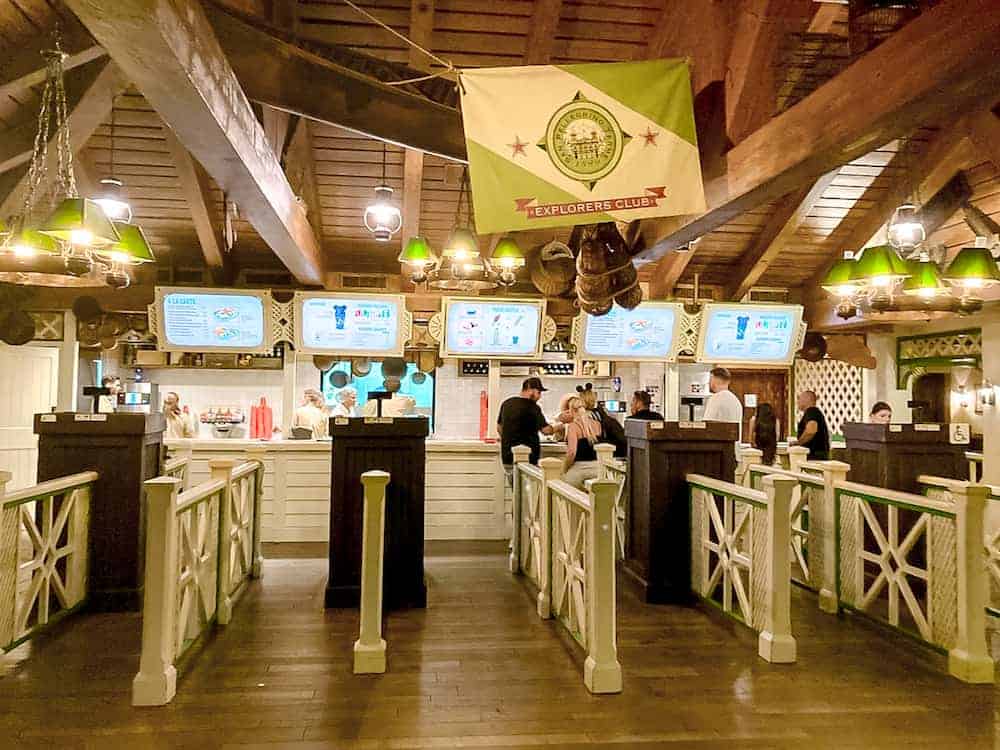 Colonel Hathis - a quick-service restaurant in Disneyland Paris - has several lanes for guests to queue up and place their food orders. Overhead is an enticing menu.