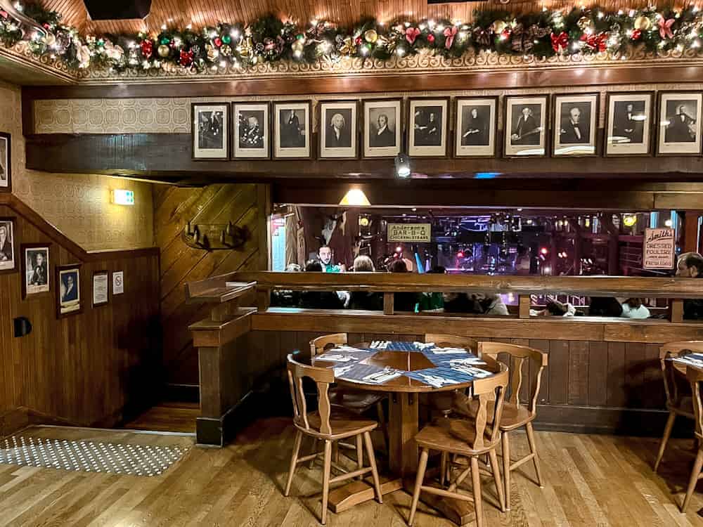 A warmly lit interior of Billy Bob’s Buffet at Disneyland Paris, decorated with festive garlands and holiday lights, creating a cosy Christmas dining atmosphere.