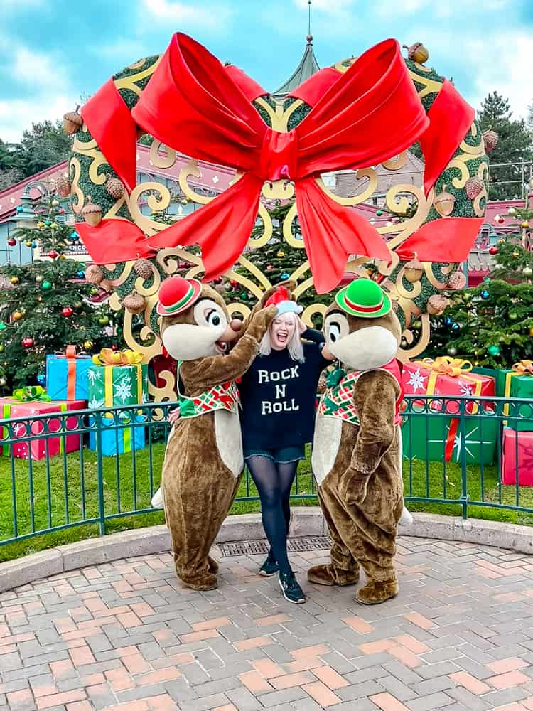 Chip and Dale dressed in festive holiday outfits, playfully interacting with a guest during a Chip and Dale Meet-and-Greet