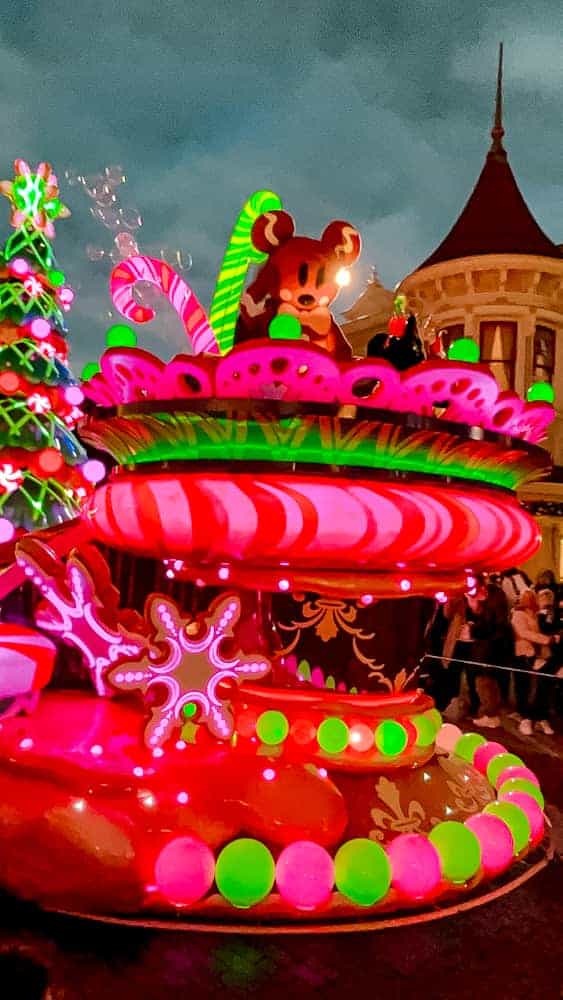 A candy-themed float featuring a giant Mickey cookie brings sweet festive vibes to Mickey’s Dazzling Christmas Parade, a treat for parade watchers.