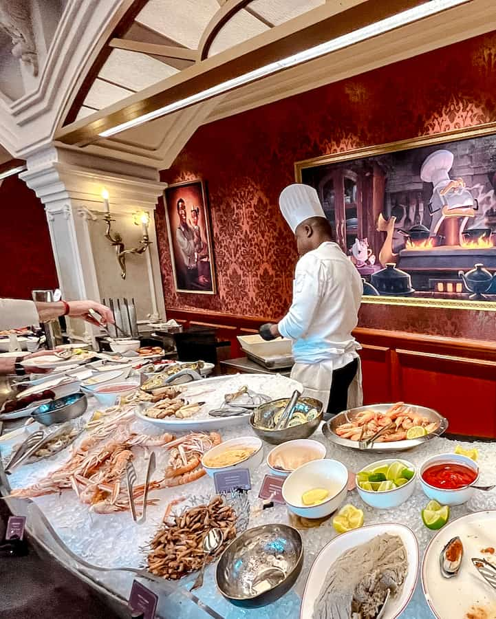 A chef attends to presenting variety of appetising dishes on display at the buffet for Royal Banquet at Disneyland Hotel in Paris including fresh seafood