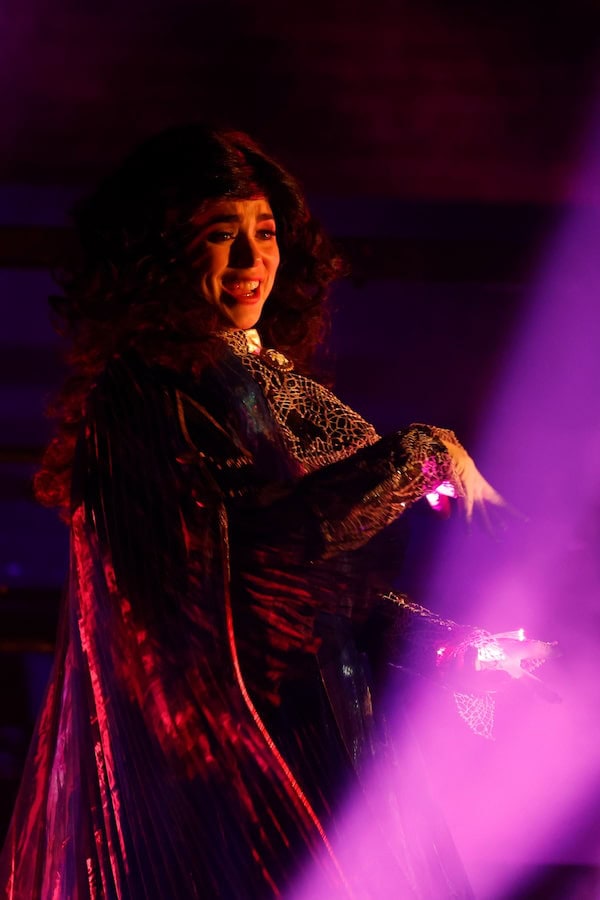 Agatha Harkness casting a spell in dramatic lighting during the Doctor Strange: Mystery of the Mystics show at Disneyland Paris.