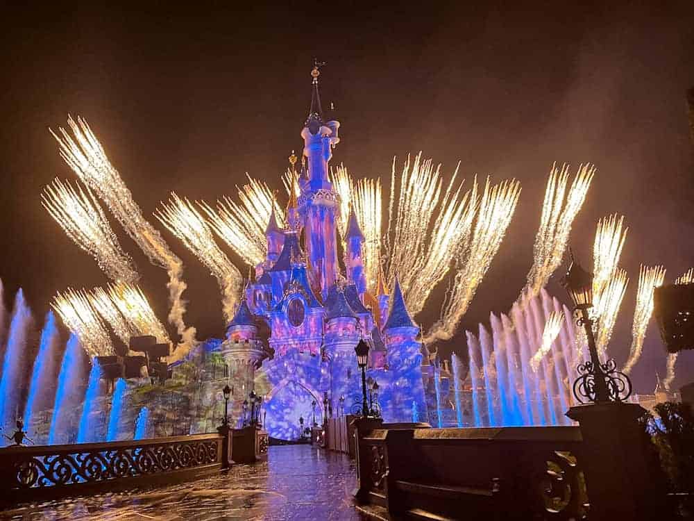 A breathtaking fireworks display over Sleeping Beauty Castle during the Disney Tales of Magic nighttime show in Disneyland Paris.