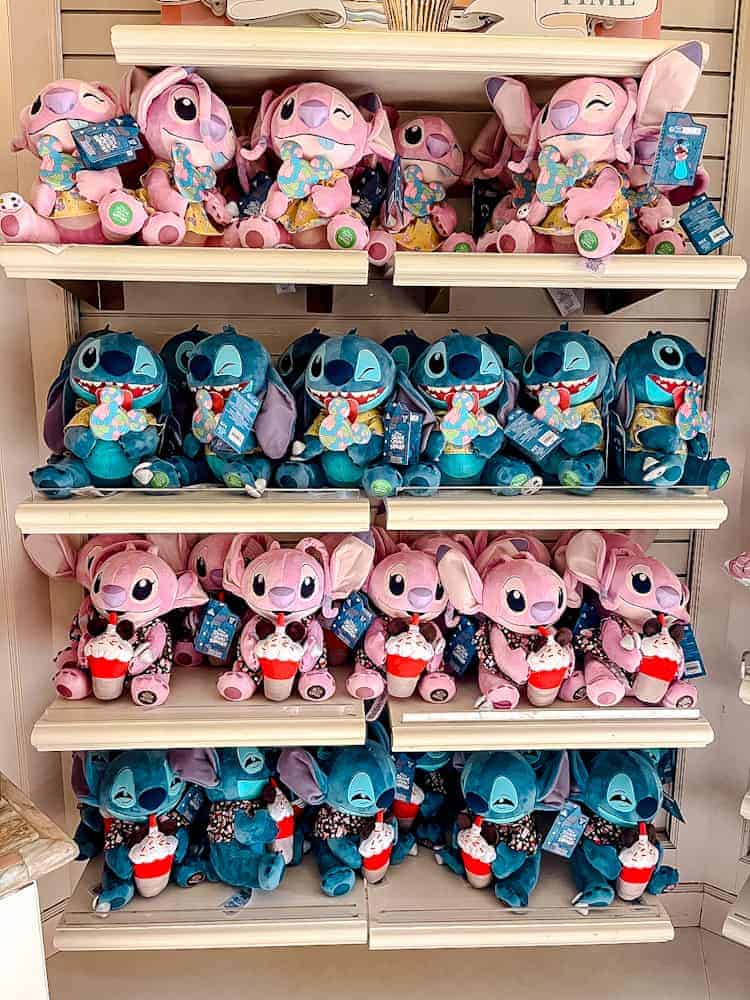 A colourful display of Stitch and Angel plush toys available at Disneyland Paris, perfect for souvenir shopping while using SkipTax to save money.