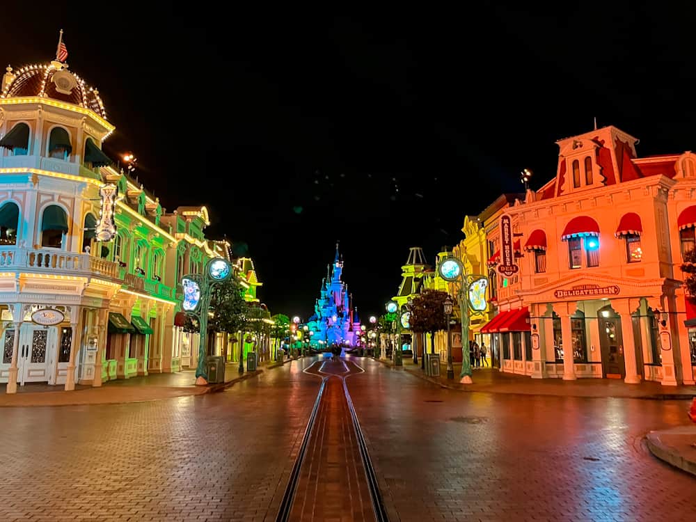 Empty Main Street at Disneyland Paris lit up at night, leading to the castle — a popular area to find the best Disneyland Paris fireworks spot.