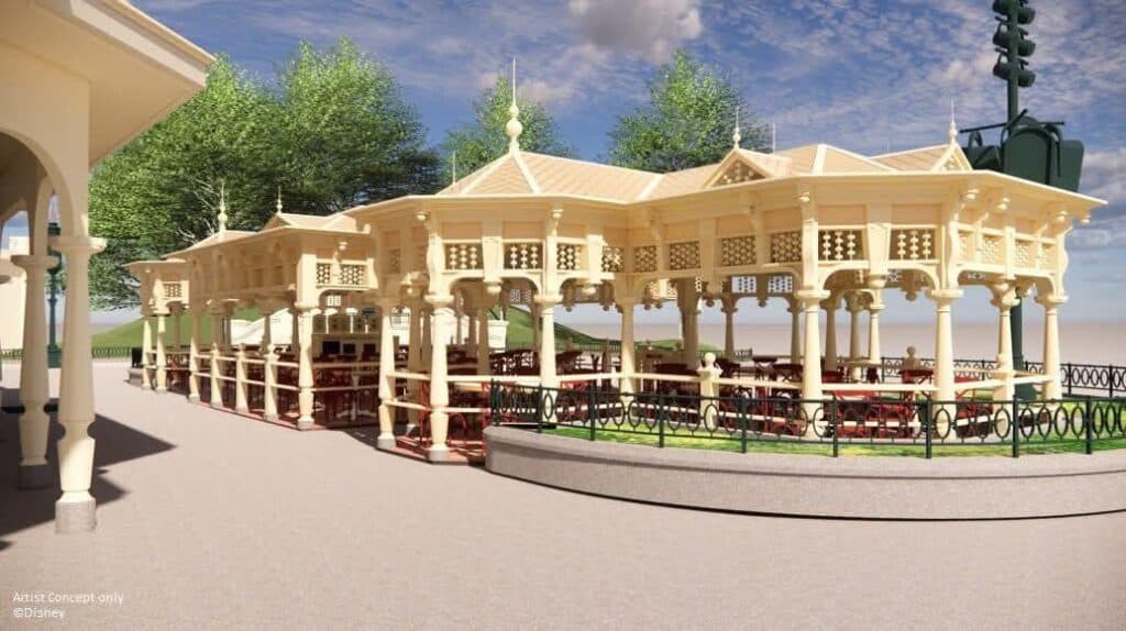 Artist concept image of the upcoming covered terrace at Casey’s Corner in Disneyland Paris, featuring a Victorian-style structure with outdoor seating and decorative latticework, scheduled to open in June 2025.