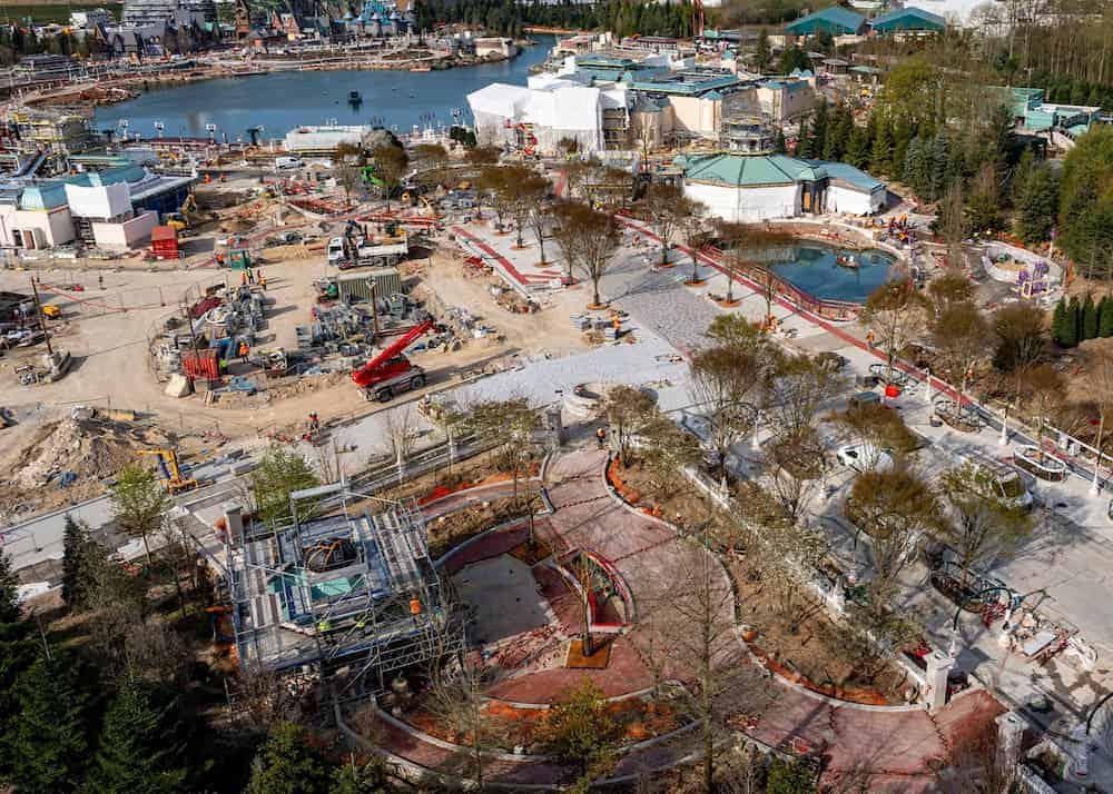 Aerial view of construction near the new Tangled-themed attraction at Disneyland Paris, showing pathways, landscaping, and lakefront development in Disney Adventure World.