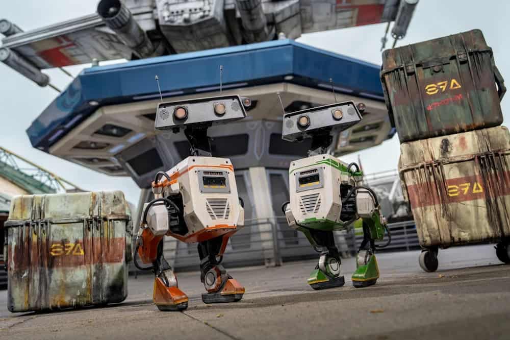 DBX droids walking near Star Tours in Discoveryland during Star Wars Day 2025 at Disneyland Paris.