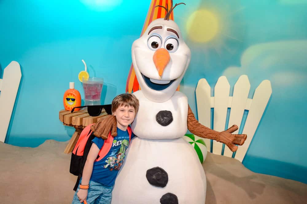 A small boy with a backpack hugging Olaf during a meet and greet in Walt Disney Studios Park, now one of the Disneyland Paris Virtual Queue locations.