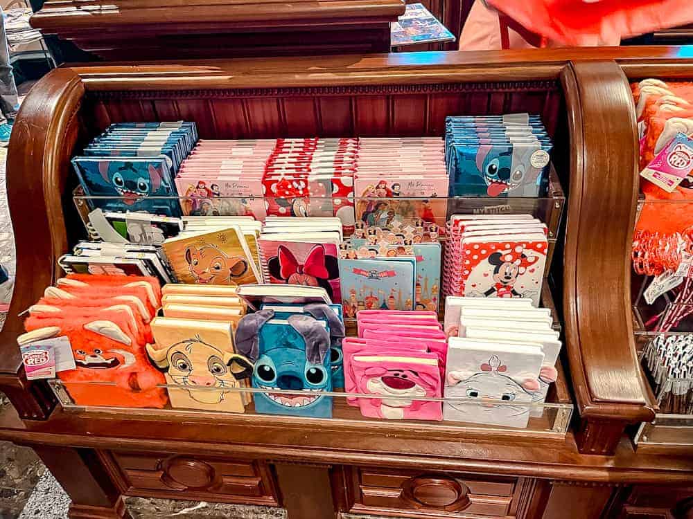 Colourful Disney notebooks including Stitch and Minnie on display in a Disneyland Paris gift shop