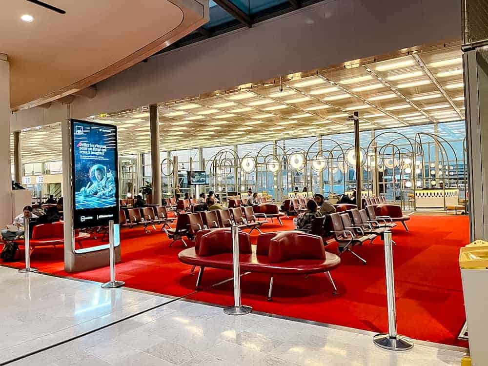 Red-carpeted departure lounge at CDG Airport in Paris after a full Disneyland Paris one day itinerary