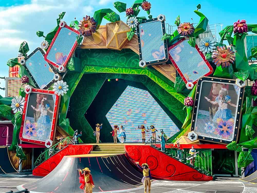 Colourful outdoor stage at Disneyland Paris with dancers and oversized cards during the Alice and the Queen of Hearts Return to Wonderland show