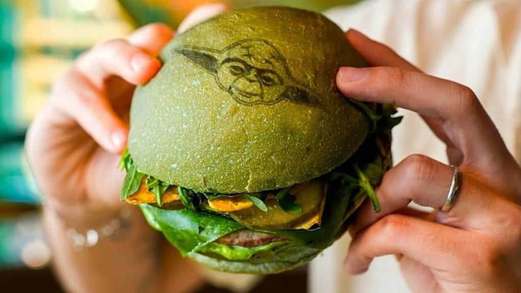 Green bun Yoda burger with Baby Yoda stamp, one of the themed snacks for Star Wars Day 2025 at Disneyland Paris.