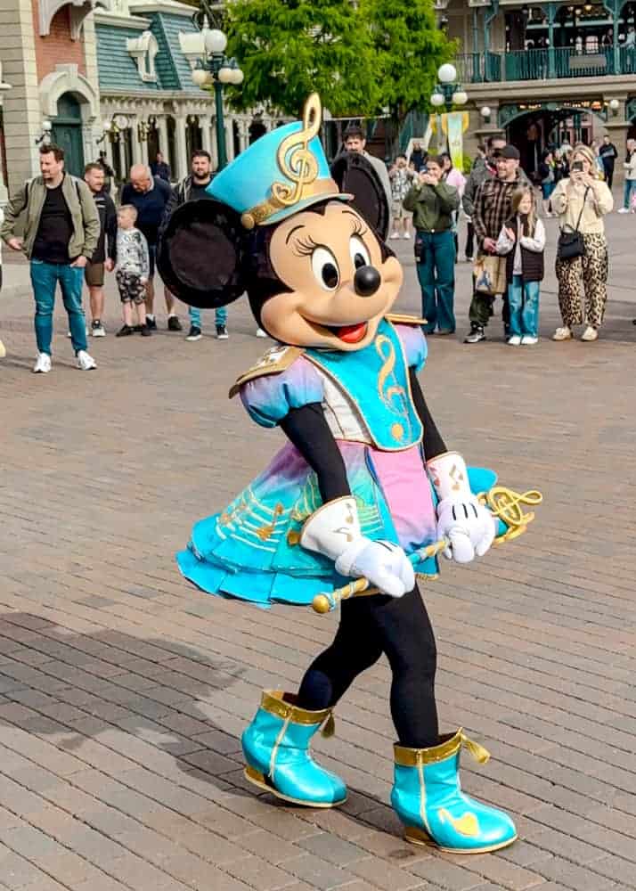 Close-up of Minnie Mouse in her sparkly blue music-themed marching band outfit. A signature look for the Disney Music Festival.