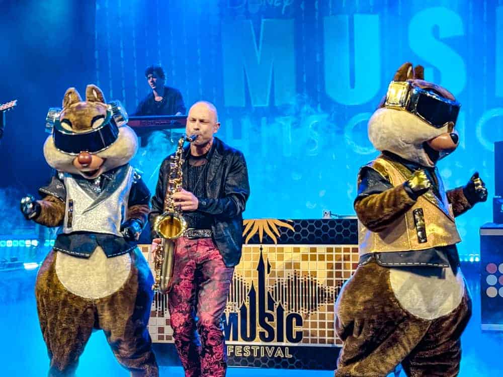 Chip and Dale in futuristic DJ costumes perform with a live saxophonist at the Disney Music Festival Hits show. High energy and full of fun!