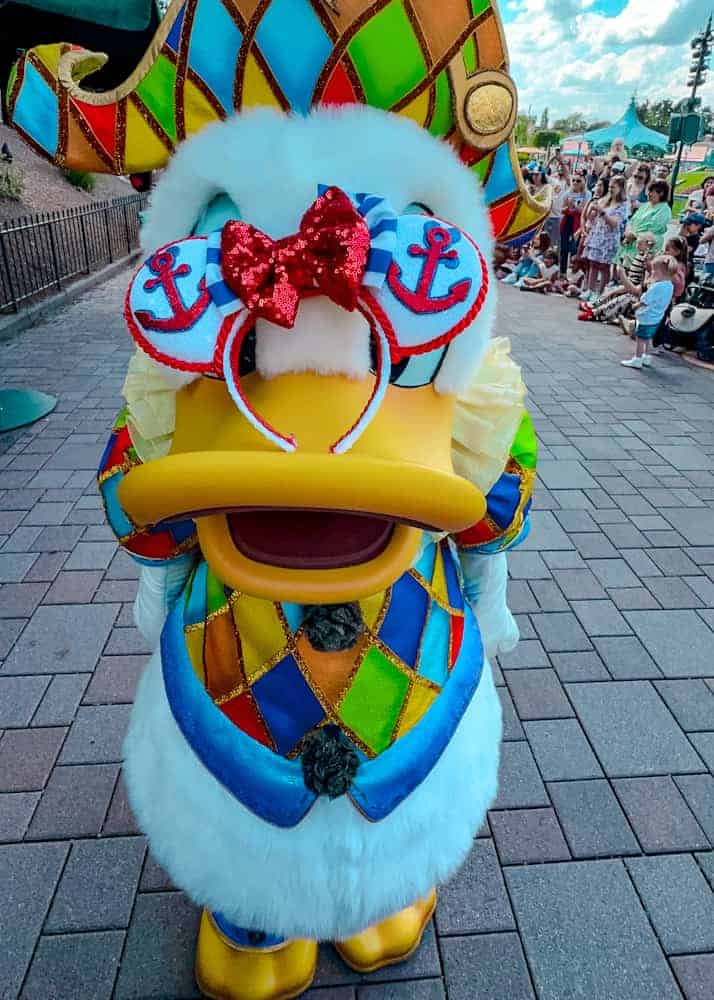 Donald Duck playfully wears a guest's sailor-themed Minnie ears during the Disney Music Festival at Disneyland Paris. A hilarious and sweet character moment.