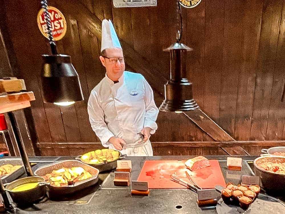 A chef at Billy Bob’s La Grange Buffet preparing roast meat at the carving station during dinner service in Disneyland Paris.