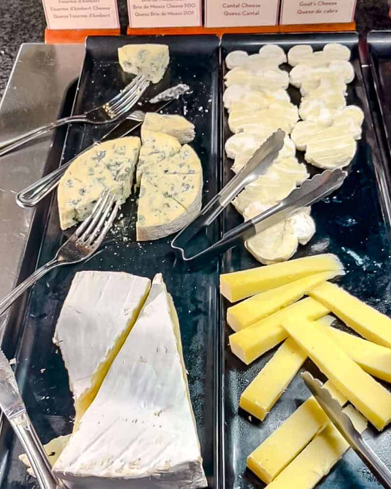 A close-up of the cheese selection at Billy Bob’s La Grange Buffet, including Brie de Meaux cut into Mickey shapes, goat’s cheese, Cantal, and blue cheese.
