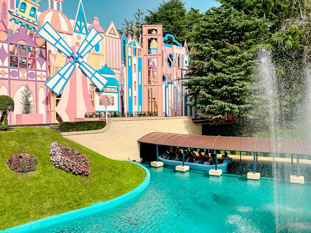 Colourful boats entering It’s a Small World ride at Disneyland Paris, with pink pastel towers and fountains – a must-see for first-time visitors planning their trip.