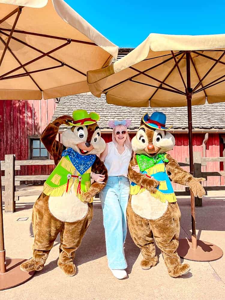 Blog post author Carrie-Anne Hall posing with Chip and Dale in colourful outfits at Disneyland Paris – a character meet perfect for planning unforgettable memories.