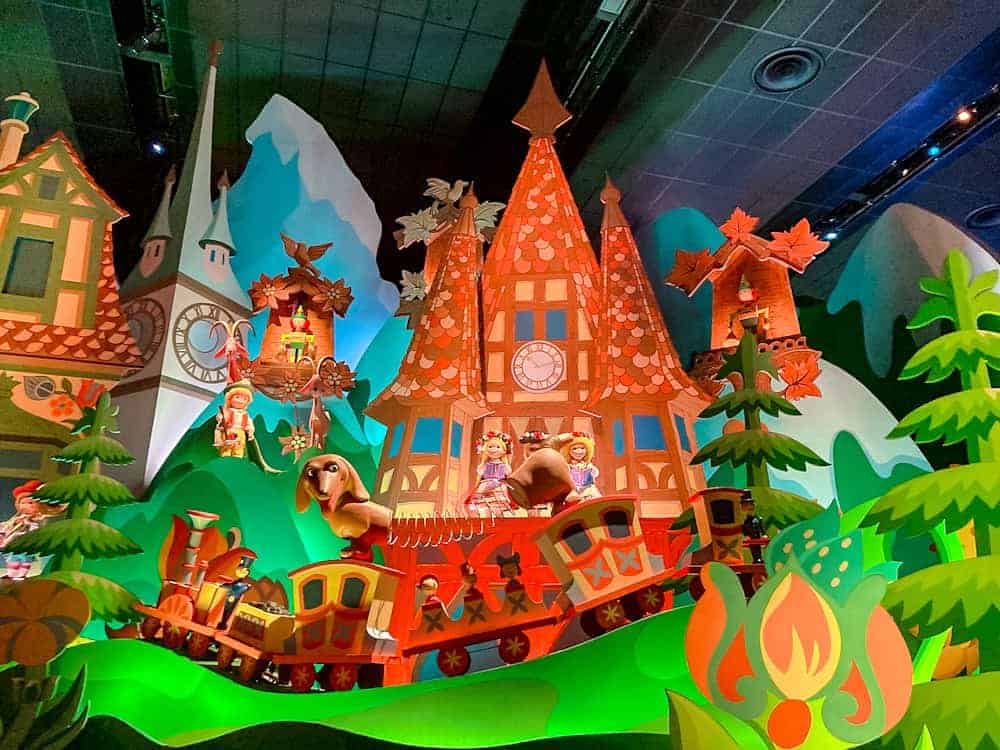 Colourful scene inside It’s a Small World ride at Disneyland Paris, featuring a toy train and whimsical buildings – a must-do for first-timers.