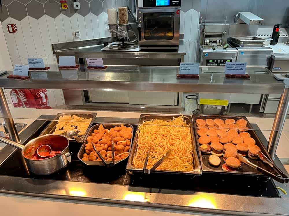 Buffet counter at Pym Kitchen in Disneyland Paris featuring pasta, nuggets, fries, and mini burgers – perfect for families planning easy meals.