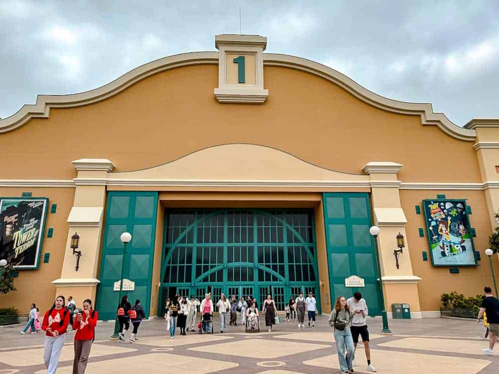 The former Studio 1 building at Disneyland Paris, now home to World Premiere, with guests entering beneath a cloudy sky.