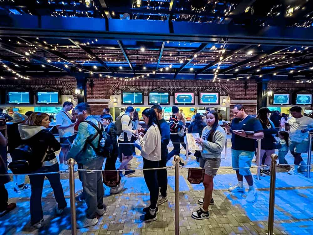 Lunchtime crowd queuing inside the Hollywood Gardens Restaurant at World Premiere Disneyland Paris under decorative string lights.