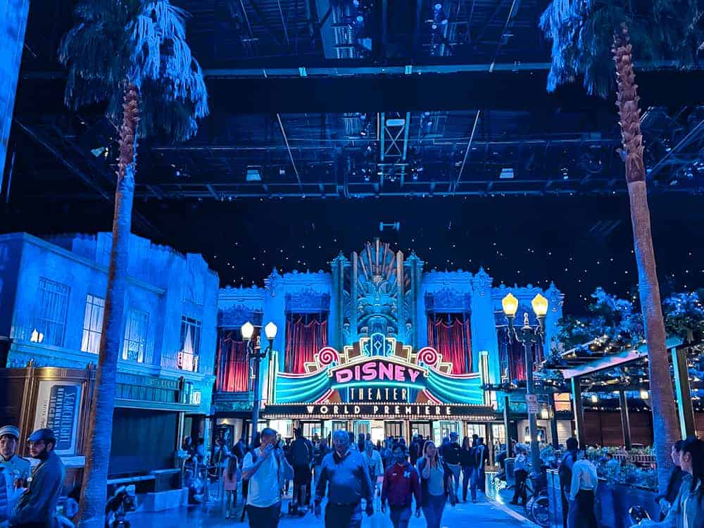 Guests entering the immersive World Premiere space at Disneyland Paris, framed by palm trees and starry skies.