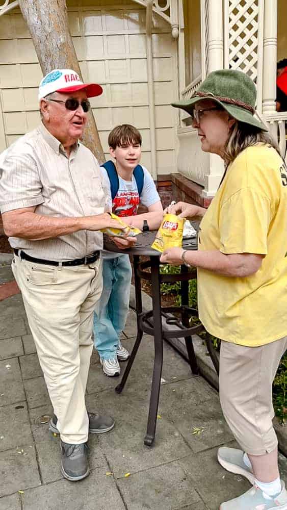 Family enjoying hot dogs and Lay’s potato chips at Refreshment Corner, Main Street USA, Disneyland California — a classic Disney food stop.