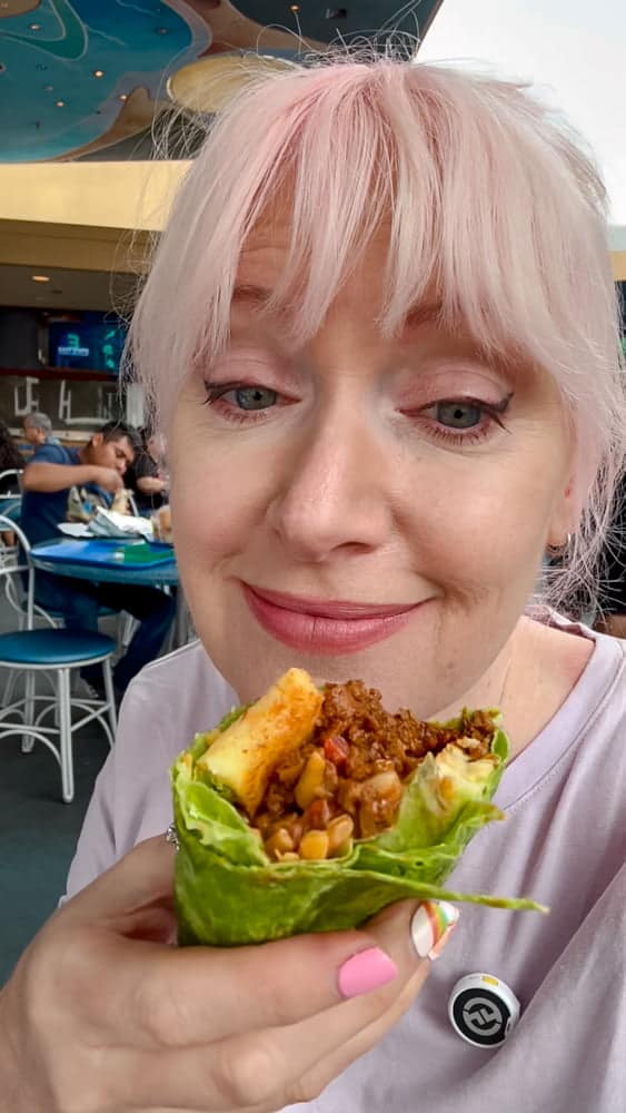 Carrie-Anne holding the Soy Chorizo Breakfast Burrito from Galactic Grill in Tomorrowland at Disneyland California — a hearty plant-based food option.