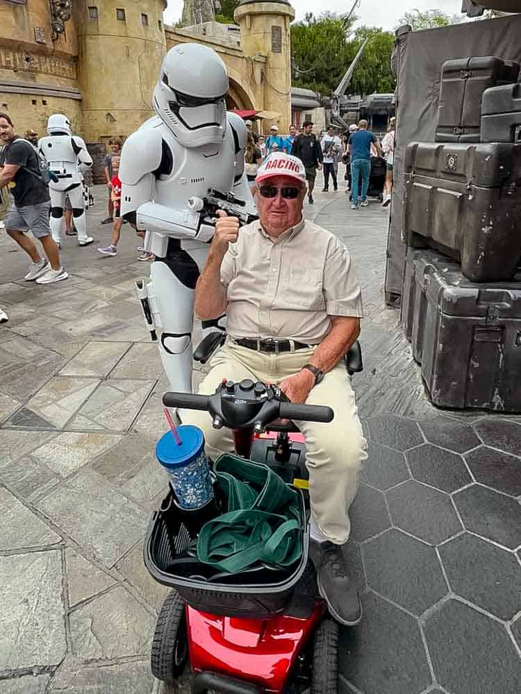 A Stormtrooper surprises my dad on his mobility scooter in Galaxy’s Edge during our 3-Day Disneyland California Itinerary.
