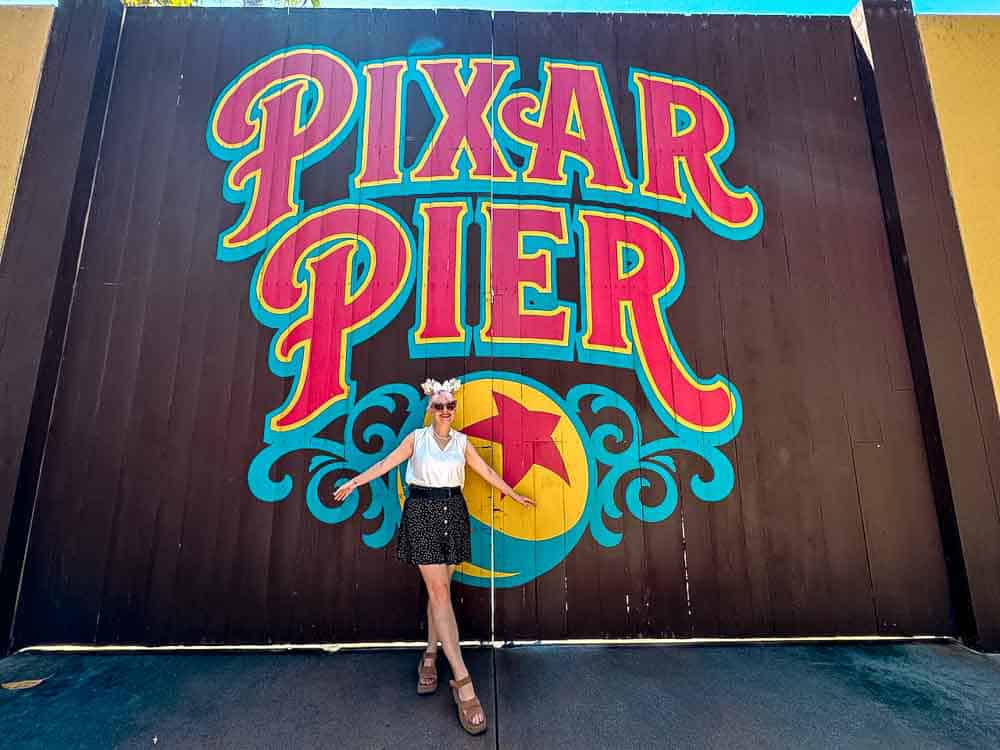 Woman posing in front of the bold Pixar Pier mural at Disney California Adventure, a colourful and iconic photo backdrop.