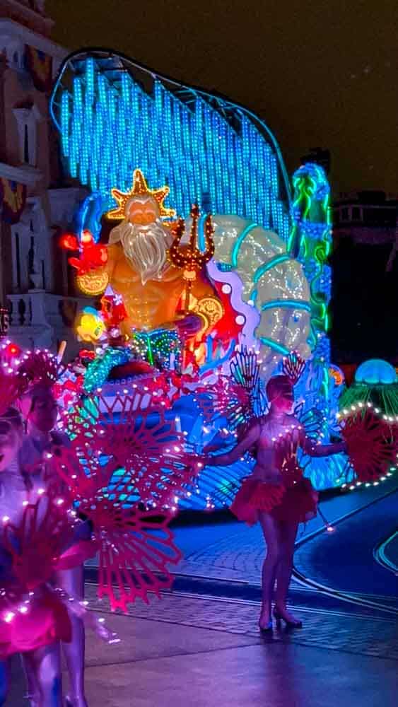 Dancers with glowing wings in front of King Triton parade float during a 3-Day Disneyland California Itinerary.