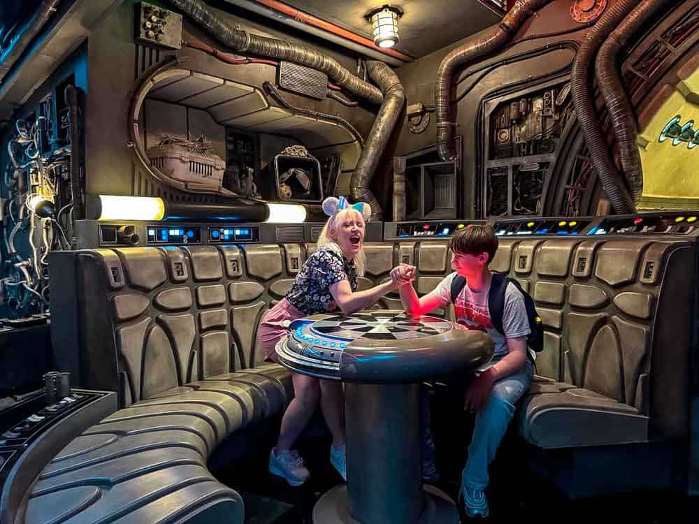 Carrie-Anne playfully arm wrestles her son inside Millennium Falcon Smugglers Run at Disneyland California Galaxys Edge