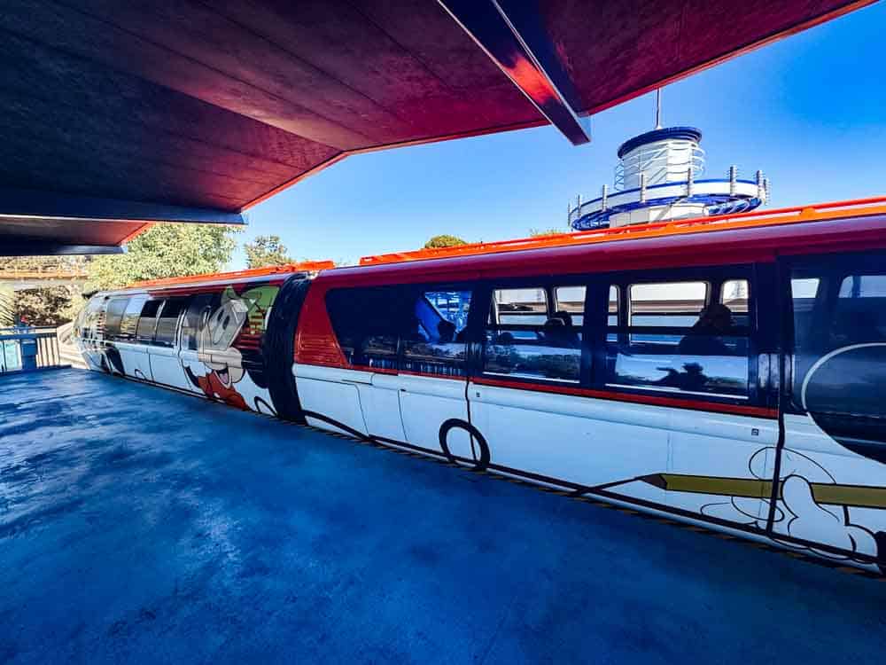 The Disneyland monorail with Mickey design parked at the station, ready to transport guests between Tomorrowland and Downtown Disney.
