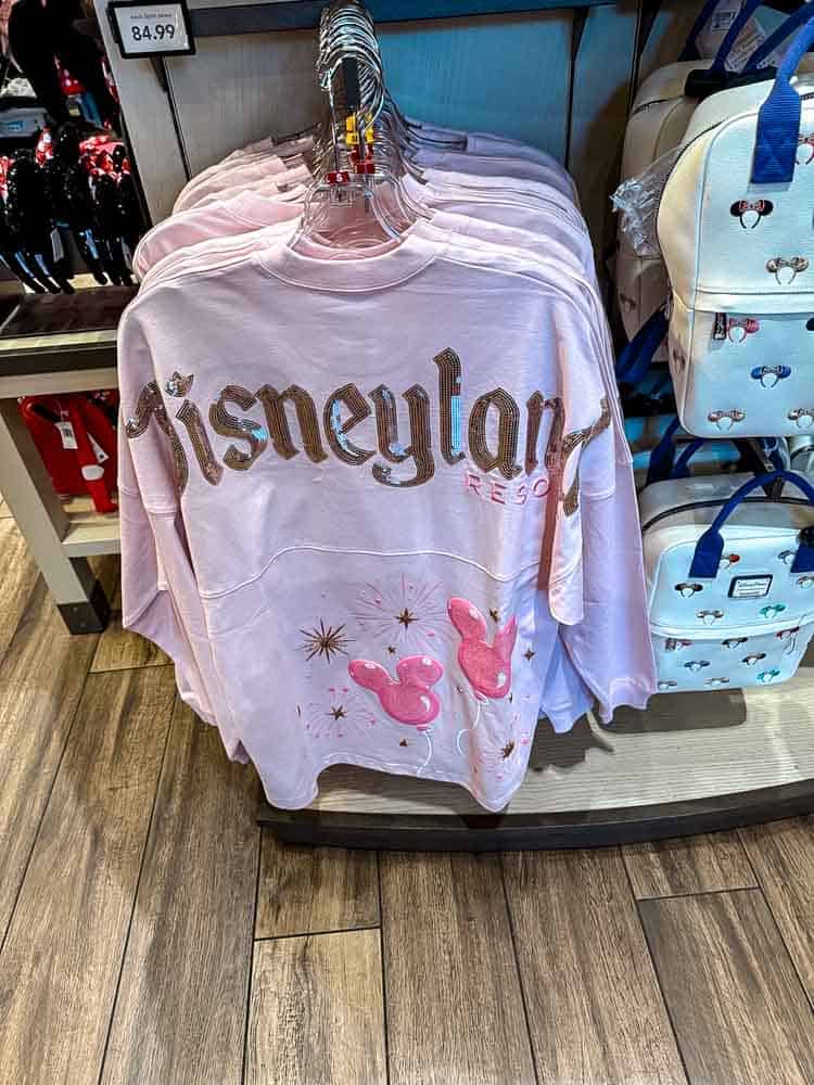 Pink Disneyland Resort spirit jersey with sparkly lettering and Mickey balloon design on display in a shop at Disneyland California.